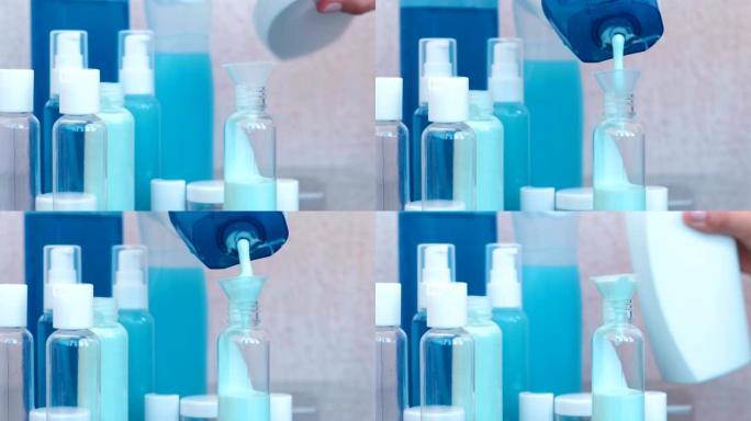女人的手通过漏斗将蓝色洗发水倒入一小瓶大洗发水中。旅行罐子。瓶子特写。