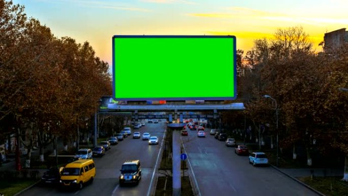 日落时快速行驶的汽车背景上带有绿色色度键的广告牌。摄像机移开了。