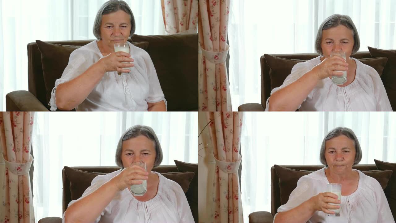 健康的高级女士喝一杯新鲜牛奶