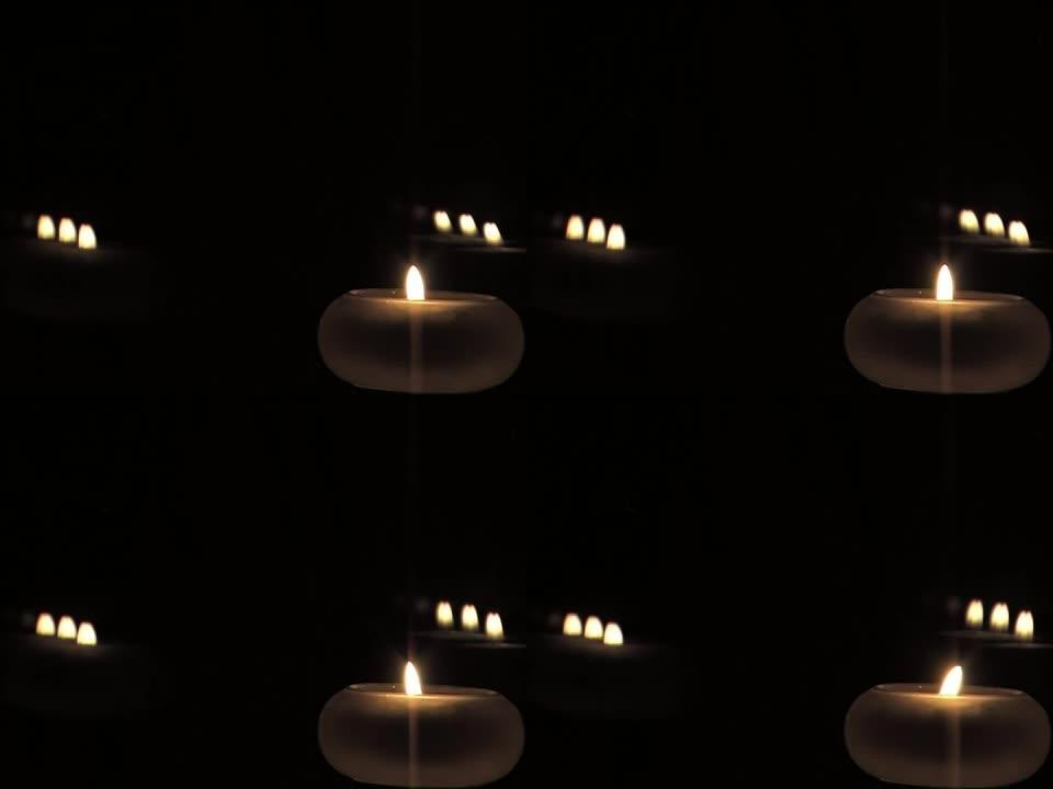 蜡烛及其反射在夜晚燃烧