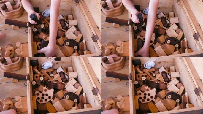 孩子从木箱里拉木制玩具。特写手。