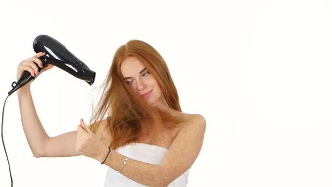 浴室里的红发女人用吹风机吹干头发，浴室