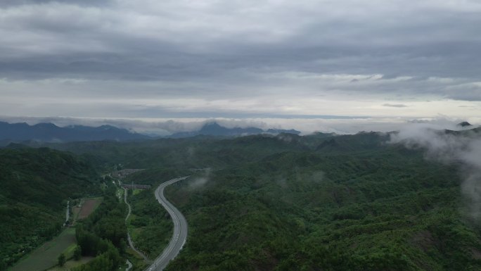 低云上空鸟瞰高速公路与汽车前进