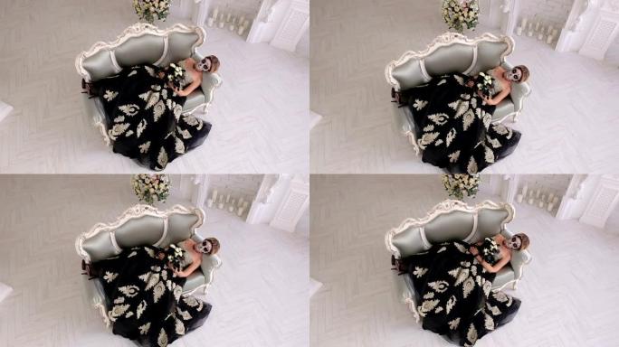 一个穿着裙子、化着骷髅妆的恐怖女人躺在复古沙发上
