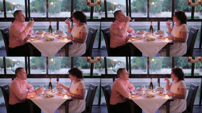 浪漫的情侣在餐桌上聊天、大笑和享受