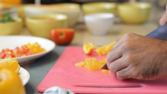 用锋利的刀在砧板上切割橘子