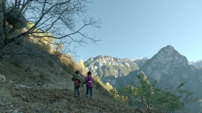 藏族男孩牵着女孩在山上奔跑