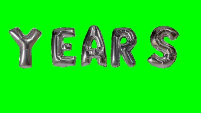 漂浮在绿色屏幕上的氦银气球字母的单词年份