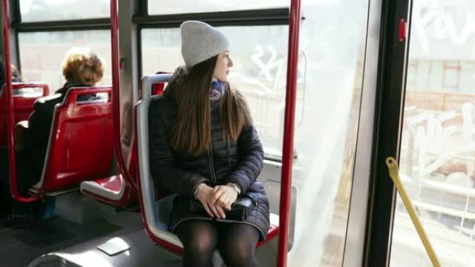 这位年轻女士乘公共交通工具去。公共汽车上的女人。徒步拍摄女孩的动作。4