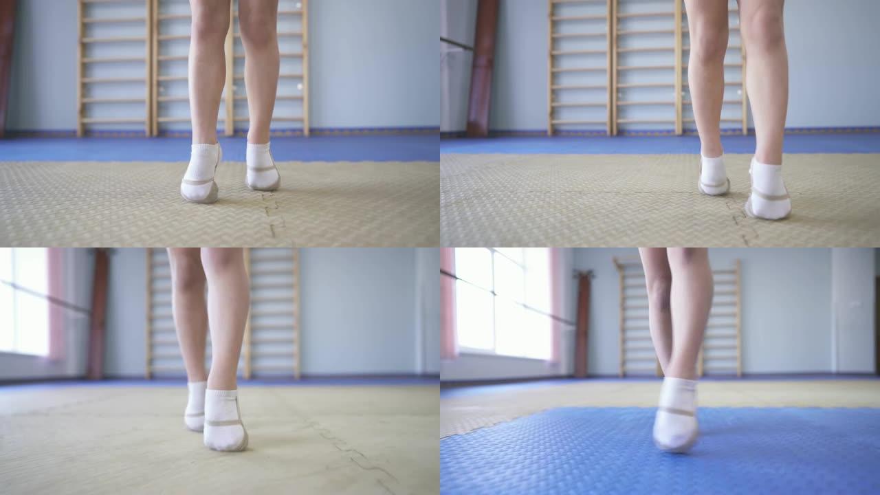 一个穿着脚尖鞋的小体操运动员在运动垫上tip脚走路的演示视频