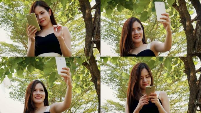 在户外公园用智能手机自拍快乐年轻亚洲女性的肖像