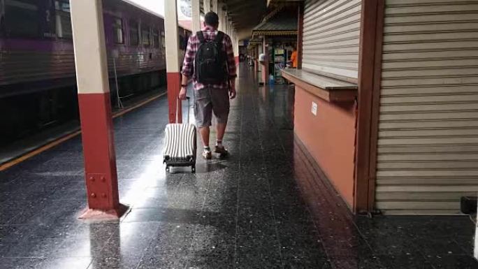 游客在火车站拖着行李走路。工作和旅行概念。