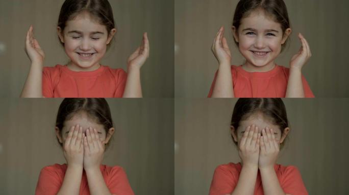 玩捉迷藏肖像的女孩。可爱的小女孩用手张开脸。玩捉迷藏，偷看嘘声。特写。