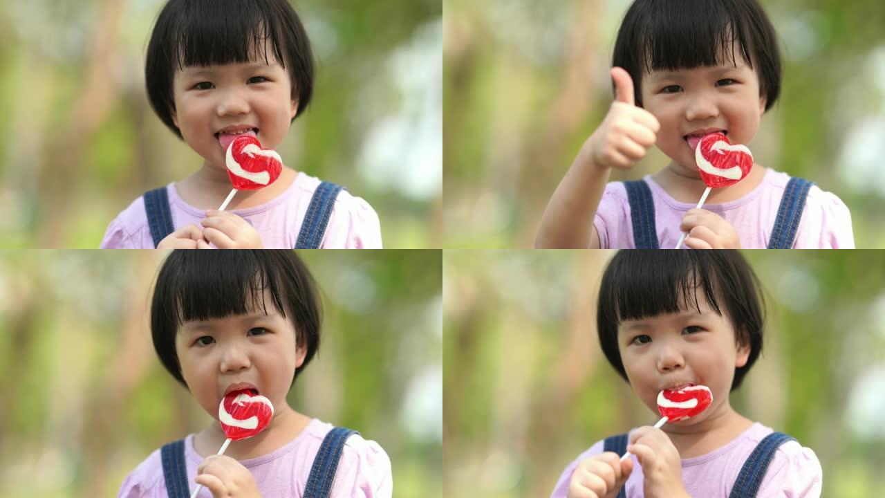 亚洲小女孩吃棒棒糖，竖起大拇指
