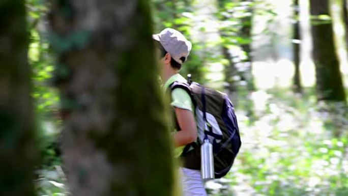 小男孩用地图独自走在森林里