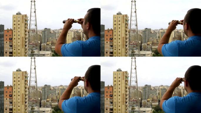男人通过望远镜看着城市