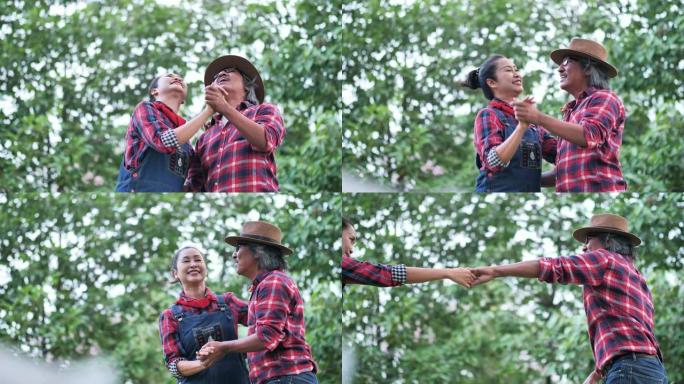 亚洲老年夫妇在家里的花园里一起跳舞。家庭，快乐，健康，环境，退休后的爱好。慢动作