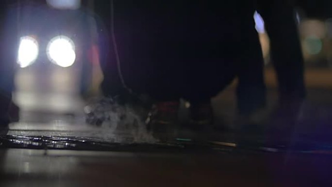 人们在晚上走过蒸腾的人孔