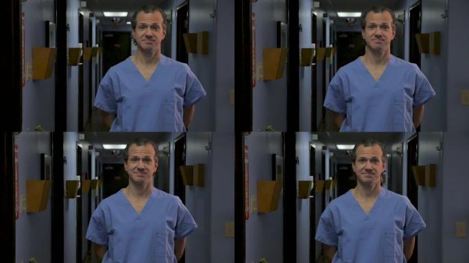 站在医院走廊上的男医生或护士穿着蓝色磨砂膏