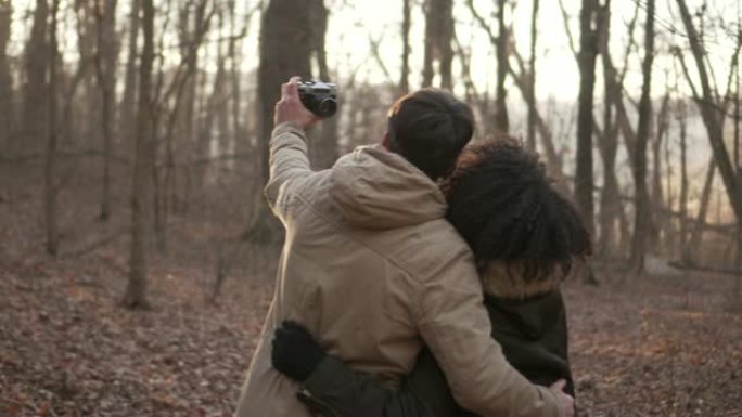 夫妇在森林使用数码相机拍摄自画像