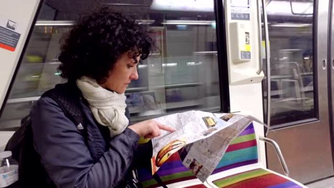 女通勤者乘坐地铁旅行，看着巴黎的地下地图