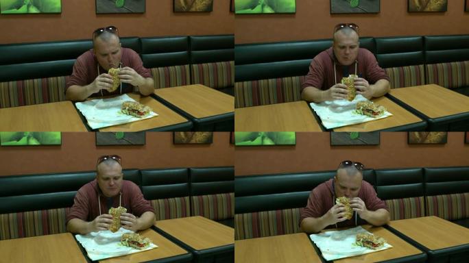 男人在咖啡馆吃三明治