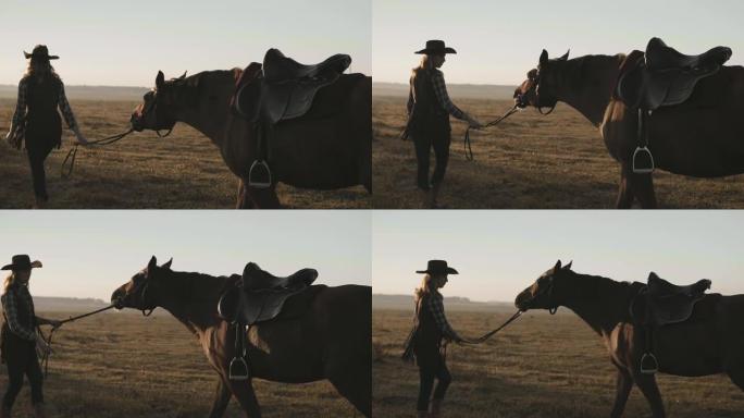 年轻女孩在日出时牵着缰绳走她那匹美丽的黑马。