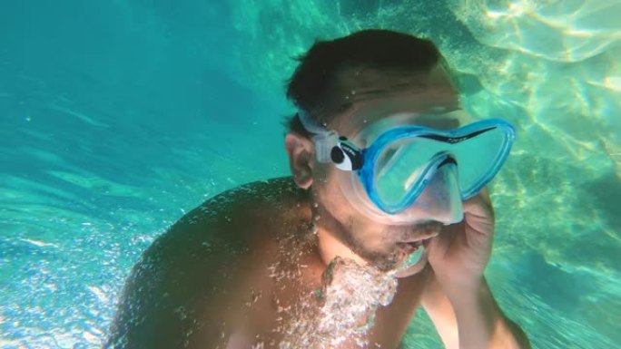 在水下愤怒的电话上戴着副面具的人。水下射进海里。意大利蓬扎岛。