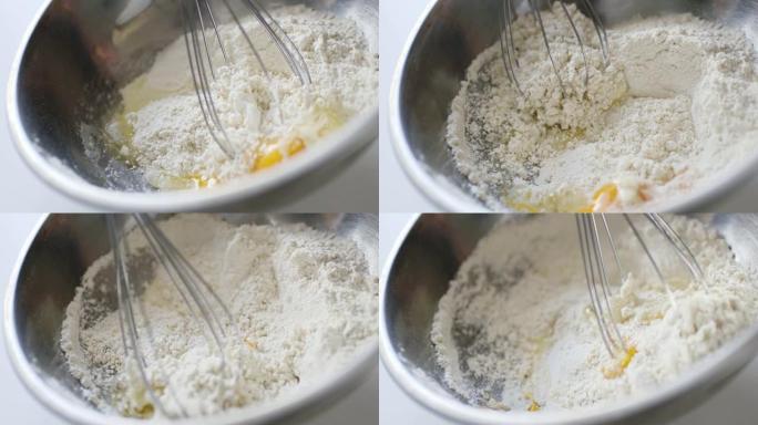 女人准备自制煎蛋卷和打蛋器混合的慢动作作物镜头。