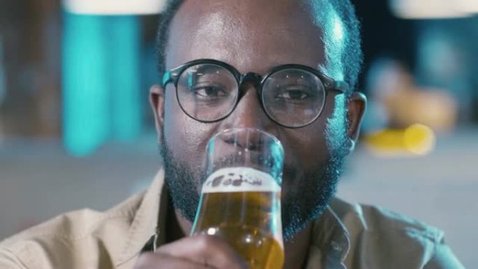 大胡子的非裔美国人碰杯喝啤酒