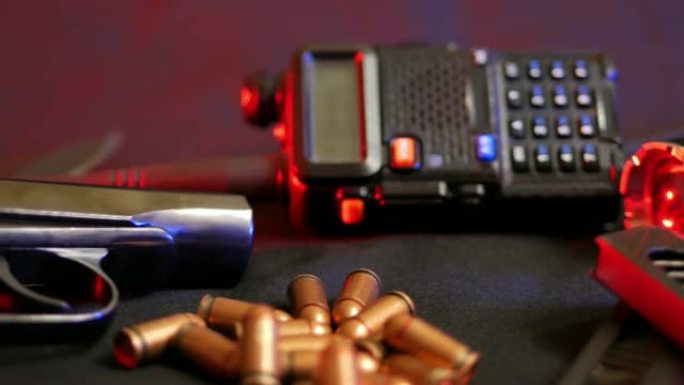9毫米马卡罗夫手枪，子弹，收音机和手电筒在黑色的背景。