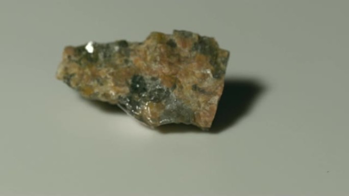 白色背景旋转的花岗岩斑岩矿物样品