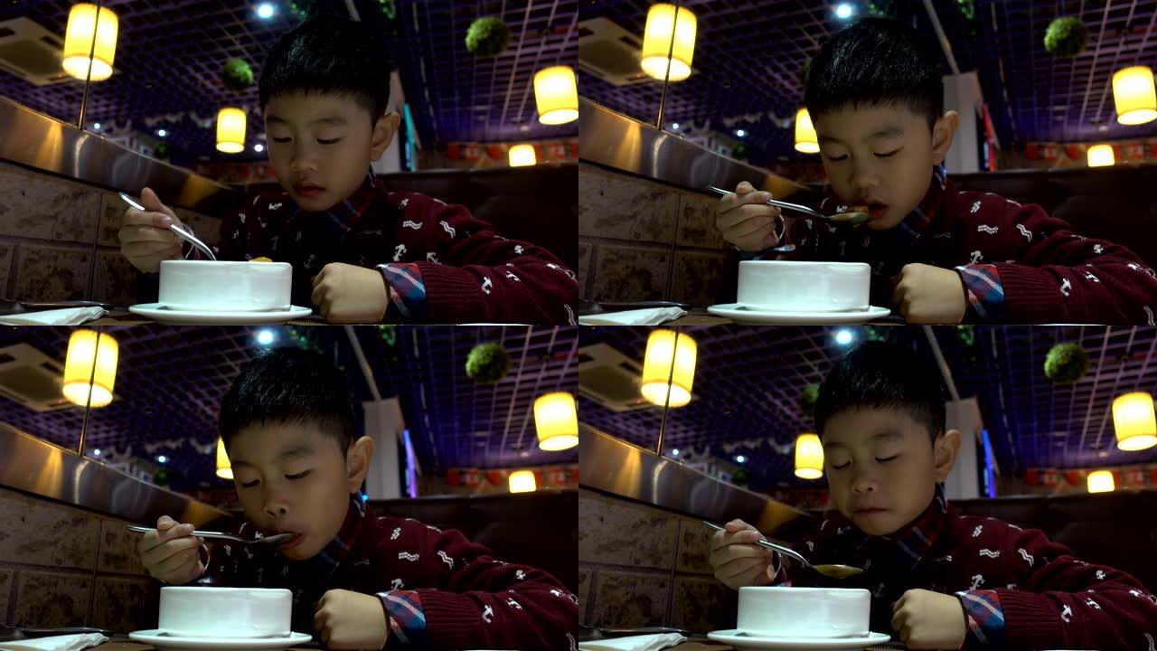 亚洲男孩在西餐厅喝汤