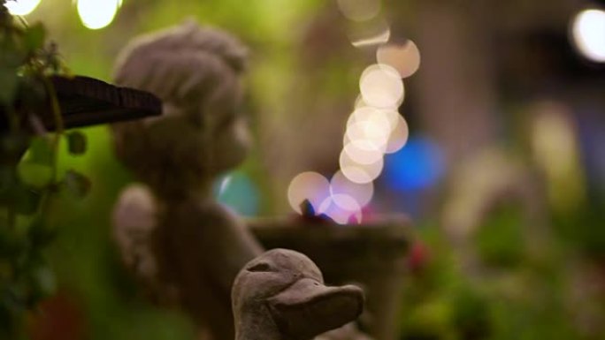 夜间花园中的石角丘比特和鸭花园装饰。抽象浪漫场景
