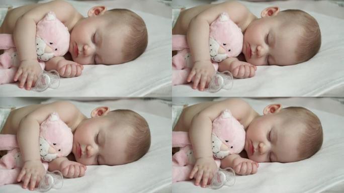 一个美丽的睡着的新生女孩和一只粉红色的猫的特写镜头