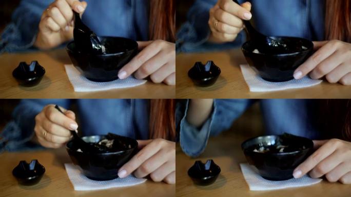 白人商务中年妇女，红发和眼镜在餐厅吃日本汤