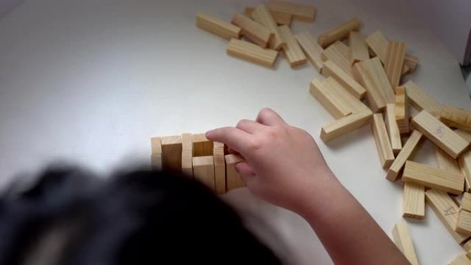 小孩子在室内玩很多木块。