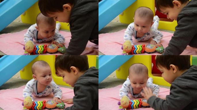 树几个月大的男婴和他的哥哥两岁的男孩在外面玩耍