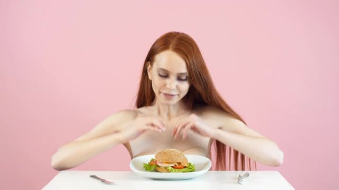 快乐的瘦女孩打破饮食，吃汉堡。违反饮食。厌食症