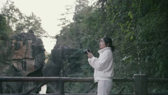 年轻女子在山上拍摄奥布光国家公园瀑布谷的照片