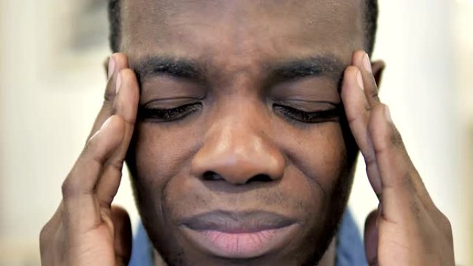 头痛，紧张的非洲男人的脸特写