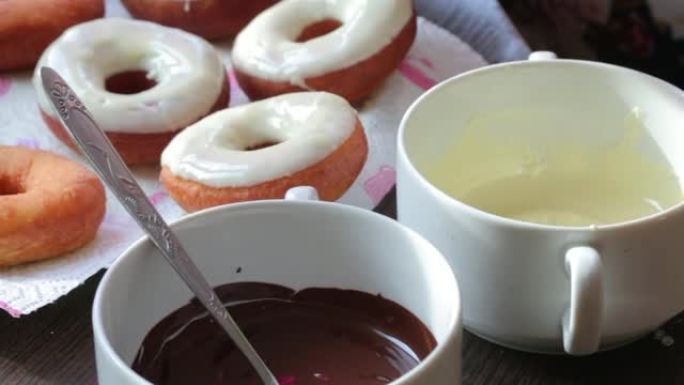 一名妇女将用葵花籽油油炸的美国甜甜圈浸入融化的巧克力中。