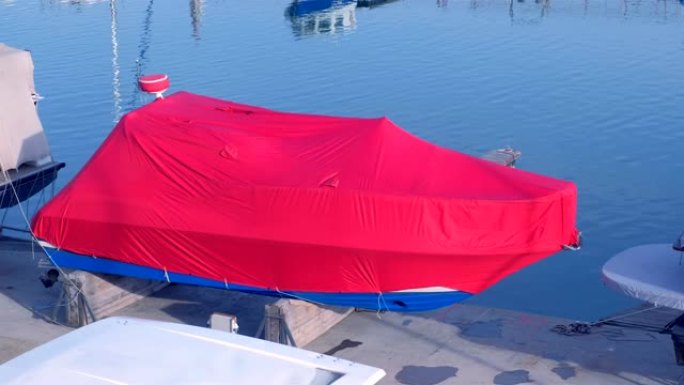 海港覆盖着红色篷布的船停在码头上。