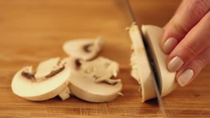 用银刀在木盘上切蘑菇。
