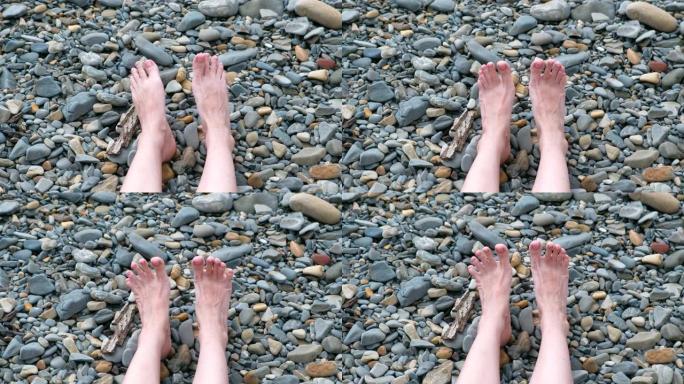 女人的脚在石头海滩靠海。