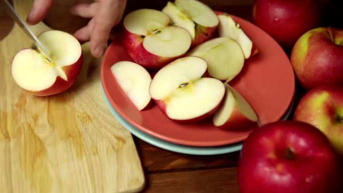 人在砧板上把苹果切成薄片。