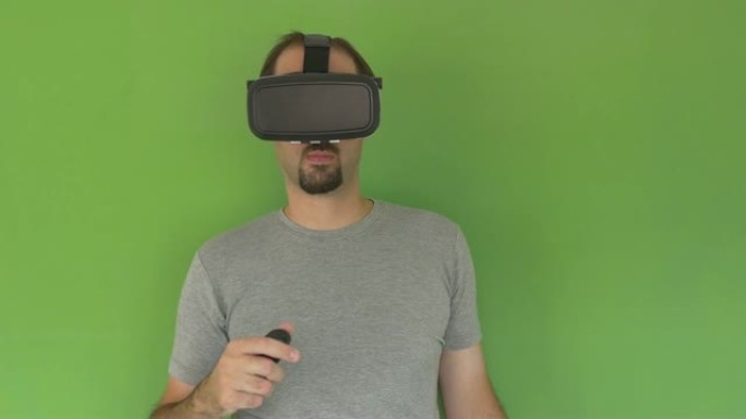戴着VR护目镜的男子站在绿色屏幕上摇摆的RC