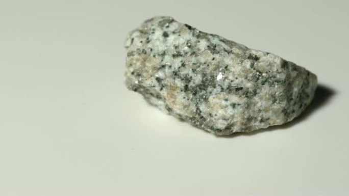 白色背景旋转的花岗岩片麻岩矿物样品