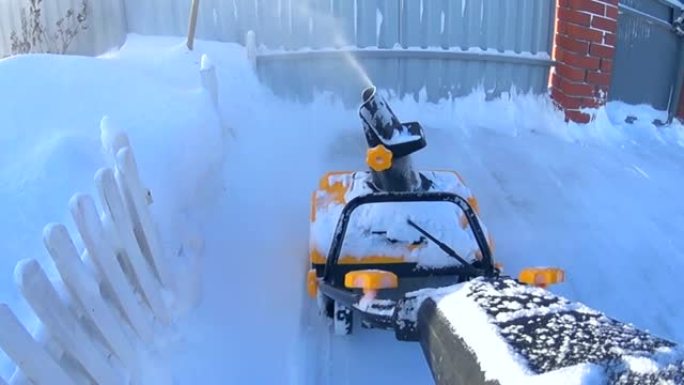 冬季在后院使用吹雪机的工人