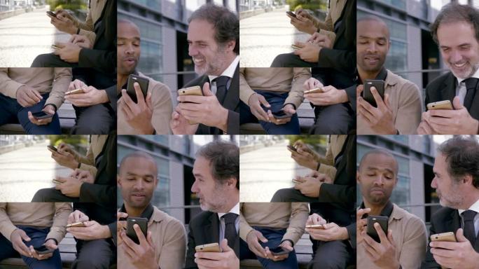 两名中年男子在户外使用智能手机。